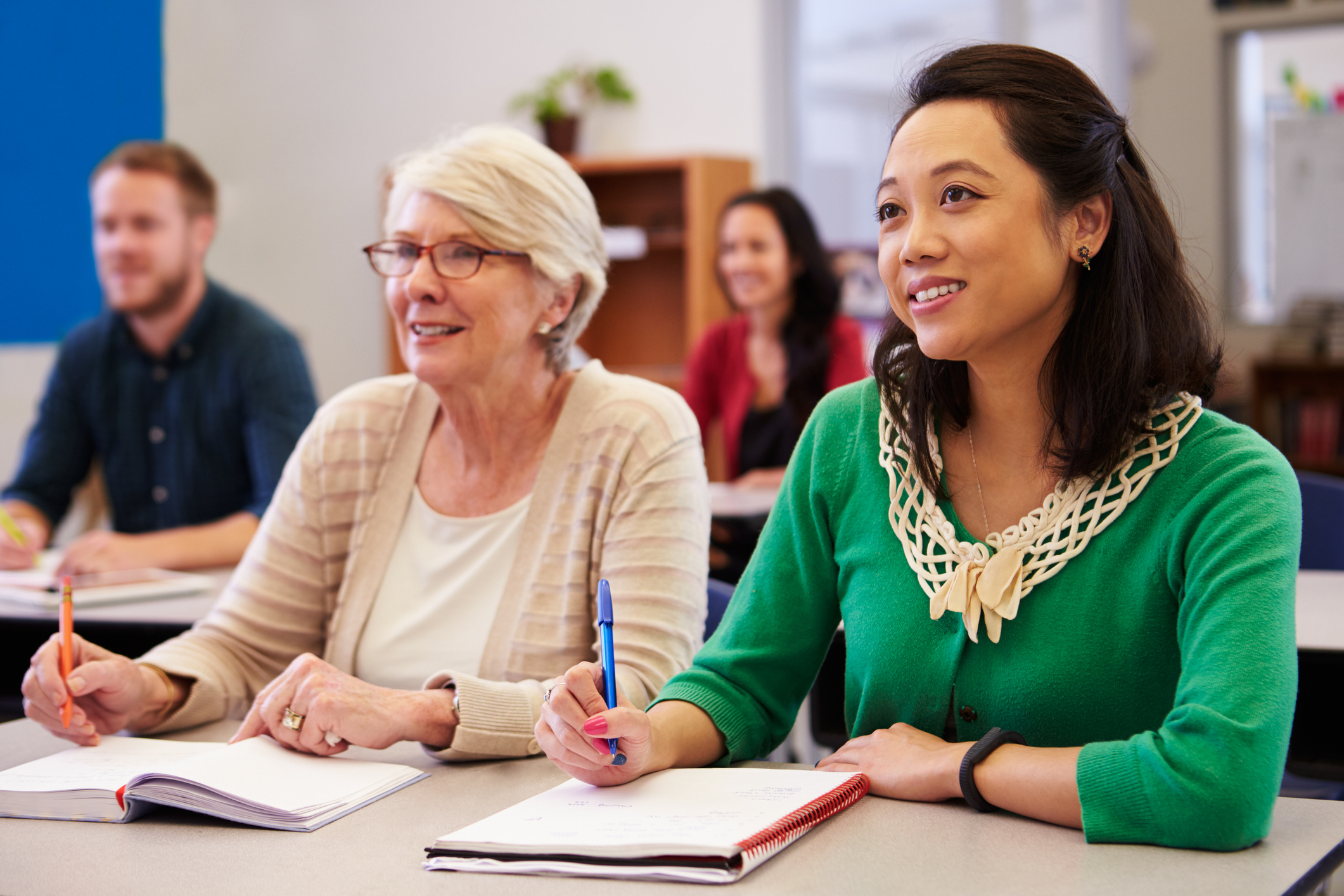 Two women sharing a desk at an adult education class